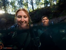 Photo of two cave divers floating in a sinkhole, created using a cheap underwater camera housing.