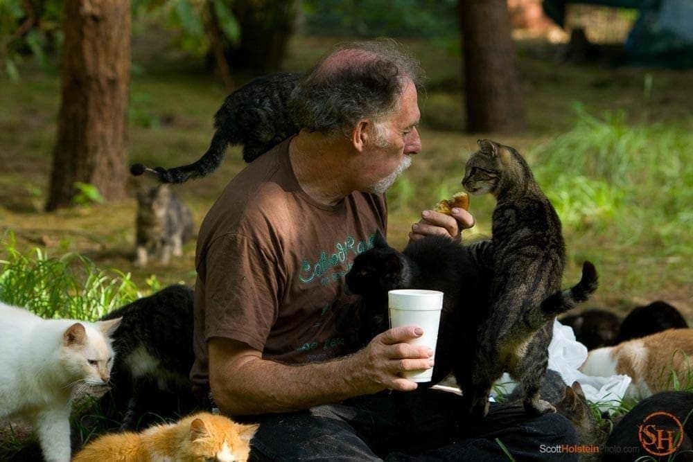 Photo of Craig Grant sharing his doughnut with a cat by Tallahassee magazine photographer Scott Holstein.