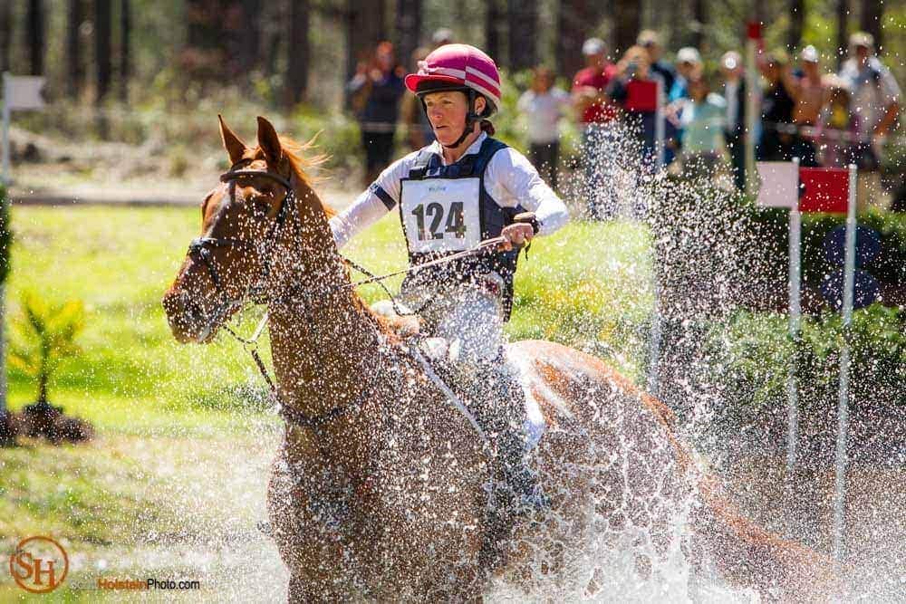 Water sprays up around a horse and rider at Red Hills Horse Trials.